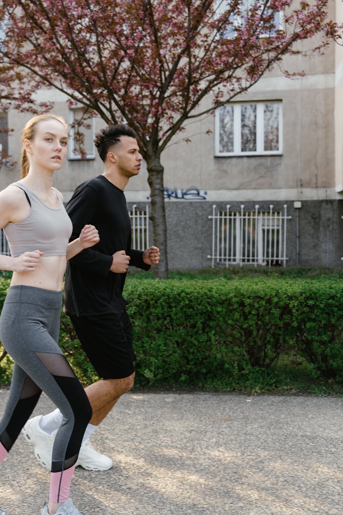 A couple jogging together on an outdoor path in spring, promoting fitness and wellness.